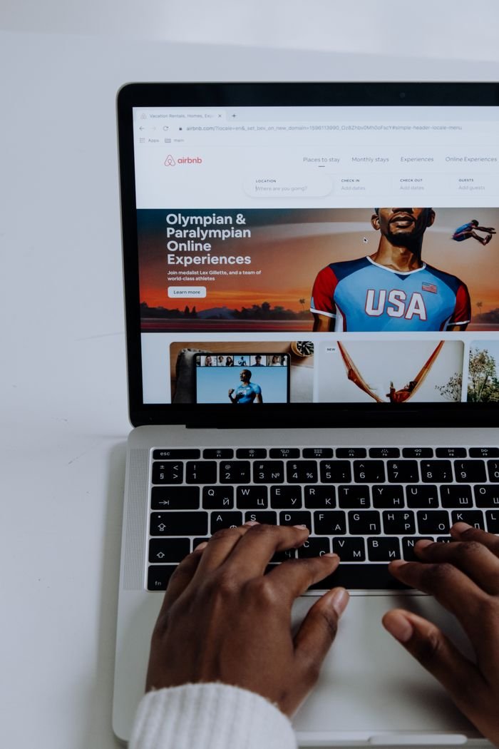 Crafting Captivating Headlines: Your awesome post title goes here Hands using a laptop to browse online Olympic and Paralympic experiences.